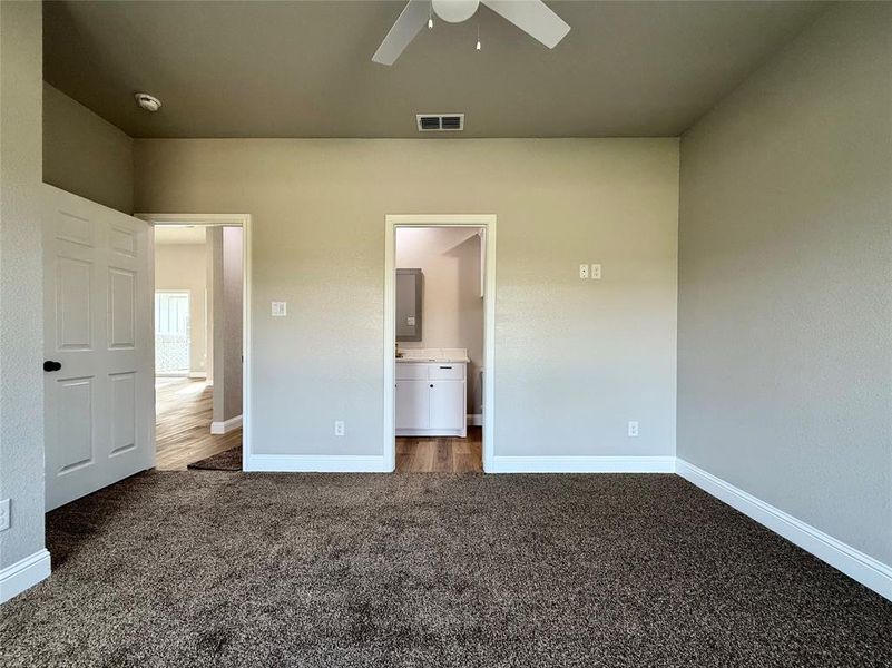 JUNIOR  MASER featuring dark carpet, ensuite bath, and ceiling fan