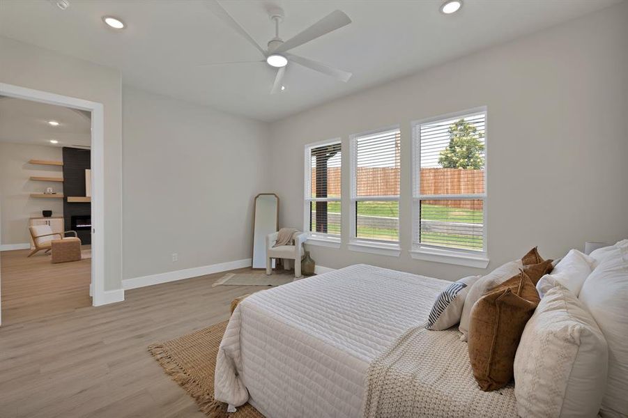 Bedroom featuring baseboards, light wood-style floors, recessed lighting, and a ceiling fan Bedroom featuring baseboards, light wood-style floors, recessed lighting, and a ceiling fan