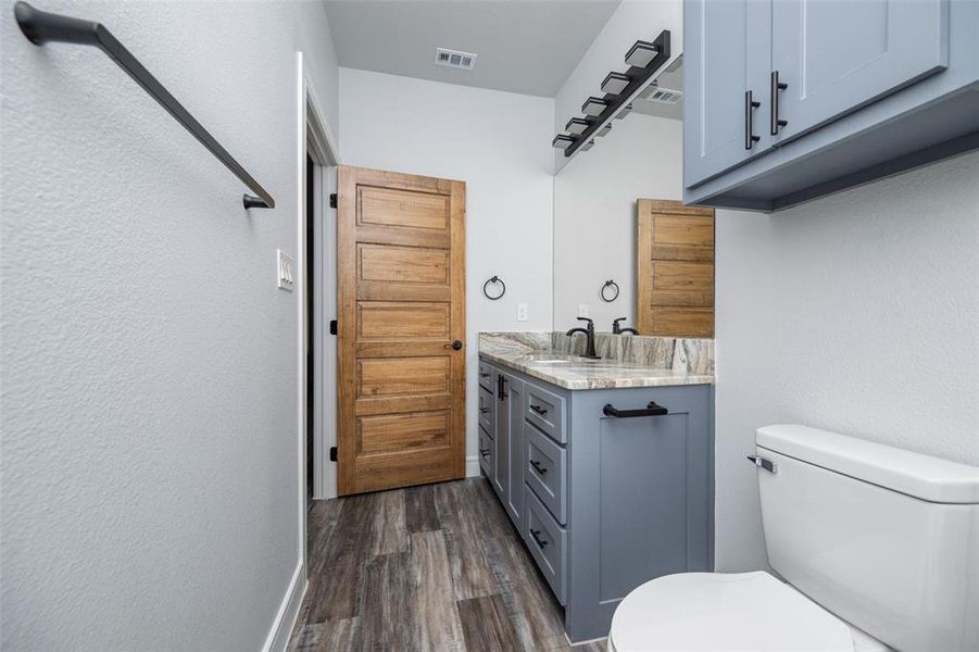 Bathroom with vanity, dark wood finished floors, and a textured wall