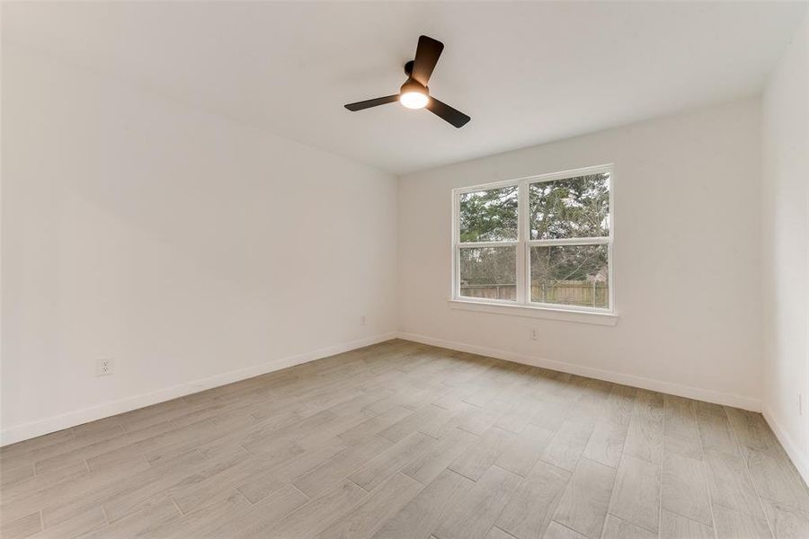 Empty room featuring ceiling fan and light wood-type flooring