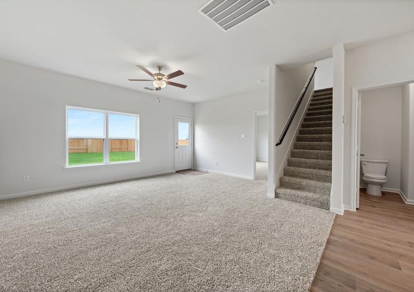 The large family room of the Driftwood has a large window with backyard views.