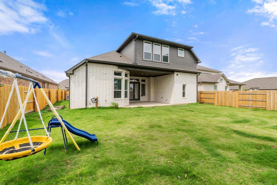 Back of property featuring a playground, a patio, and brick siding Back of property featuring a playground, a patio, and brick siding