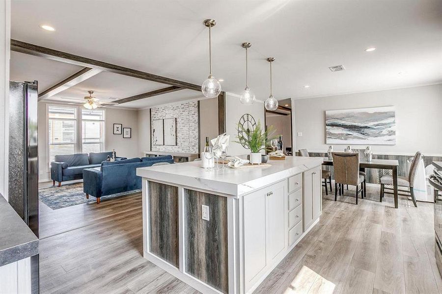 Kitchen featuring white cabinetry, a center island, ceiling fan, pendant lighting, and light hardwood / wood-style floors