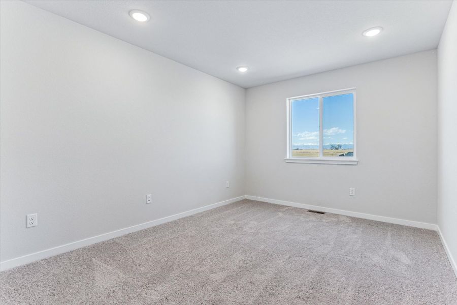 A room with a window and a carpet.