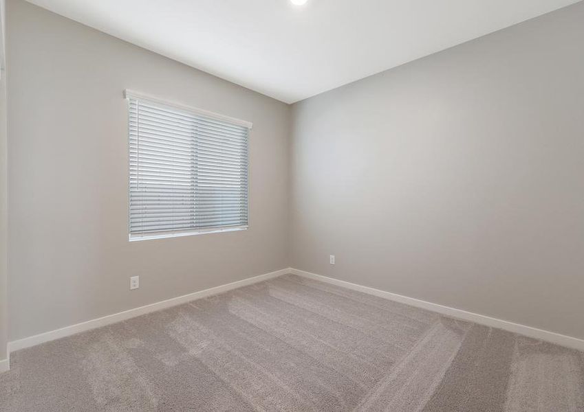 Secondary bedroom with tan carpet and recessed lighting.