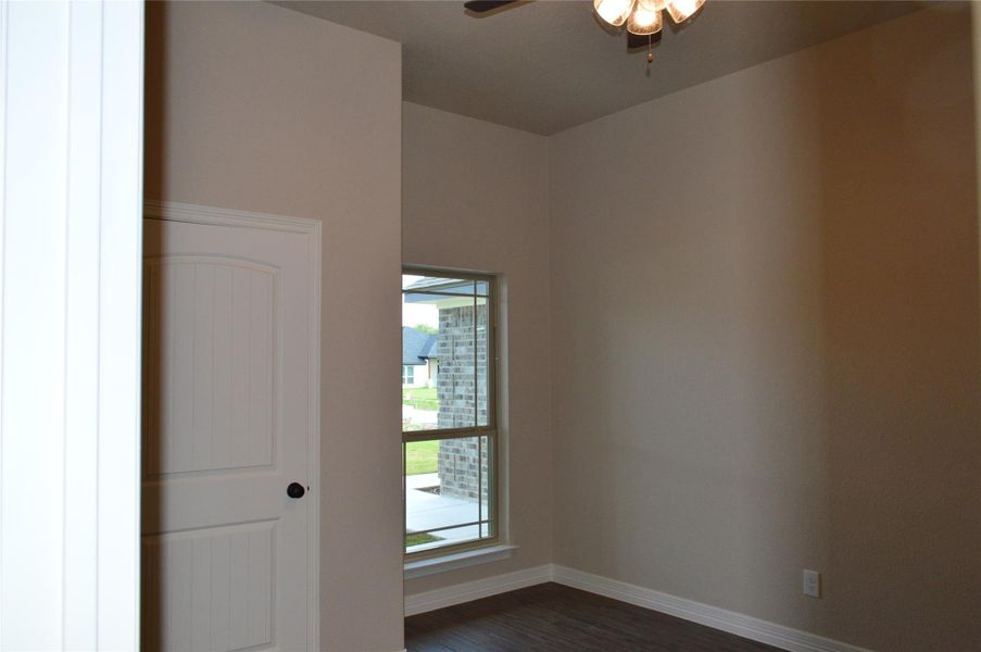 Spare room with ceiling fan and dark wood-style floors