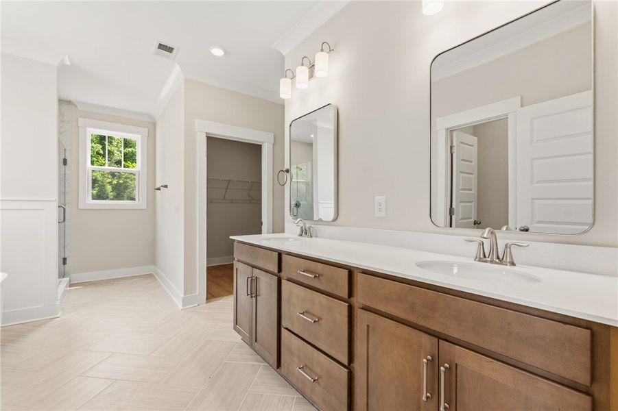 Double vanities and modern mirrors elevate this br