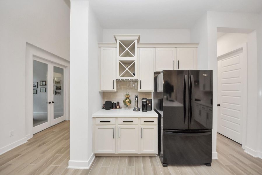 Charming built-in beverage station with wine cubbies, glass holders, and additional cabinet storage.