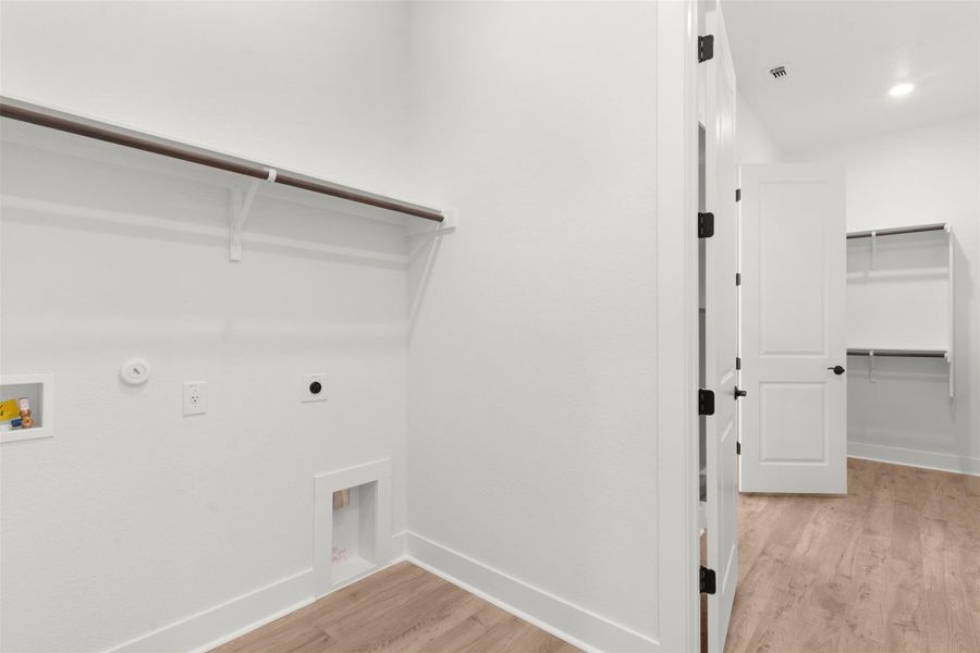 Laundry area featuring light wood-type flooring, hookup for a gas dryer, electric dryer hookup, washer hookup, and recessed lighting Laundry area featuring light wood-type flooring, hookup for a gas dryer, electric dryer hookup, washer hookup, and recessed lighting