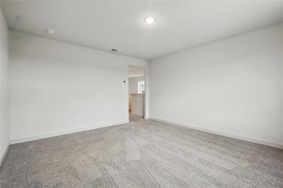 Carpeted spare room featuring baseboards and visible vents Carpeted spare room featuring baseboards and visible vents