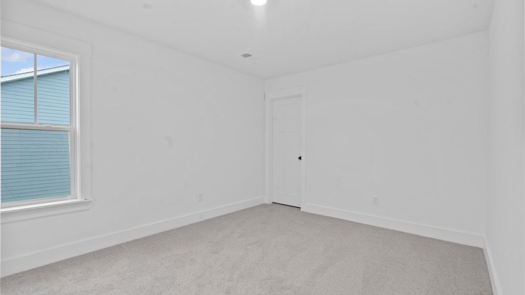 Elegant bedroom retreat featuring soft carpeting and a thoughtfully designed walk-in closet