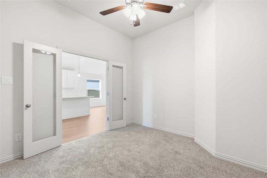 Unfurnished bedroom with light colored carpet and ceiling fan Unfurnished bedroom with light colored carpet and ceiling fan