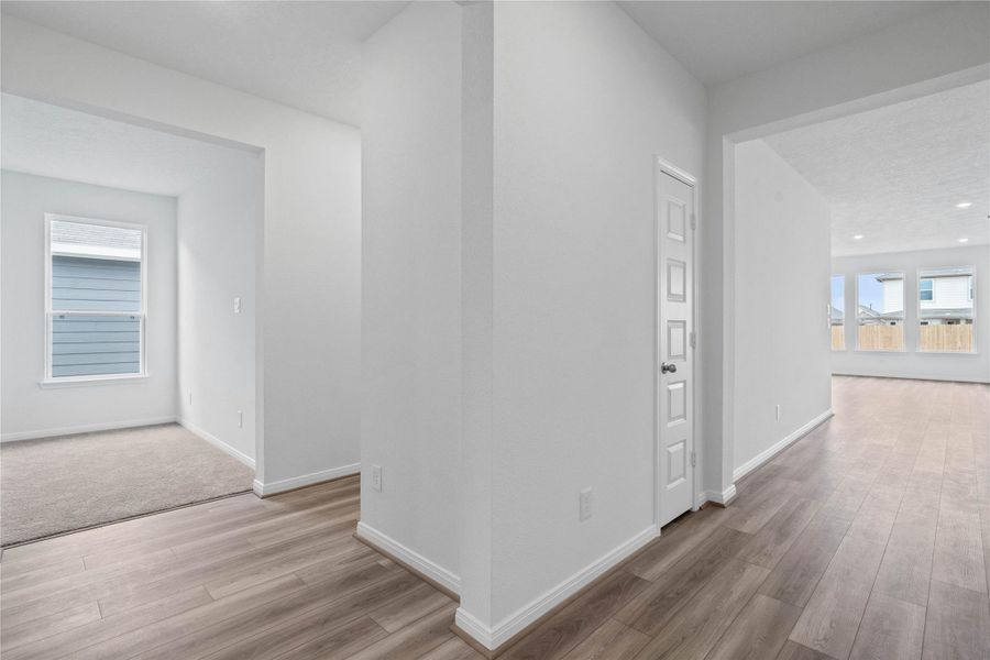 Across the home from the secondary bedrooms and bathroom is a hallway that leads to the Den, laundry room, and Primary Bedroom. Across the home from the secondary bedrooms and bathroom is a hallway that leads to the Den, laundry room, and Primary Bedroom.