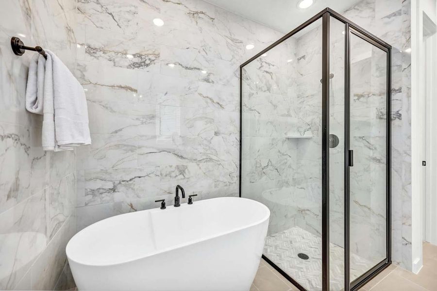 Full bathroom with a freestanding bath, a marble finish shower, and recessed lighting