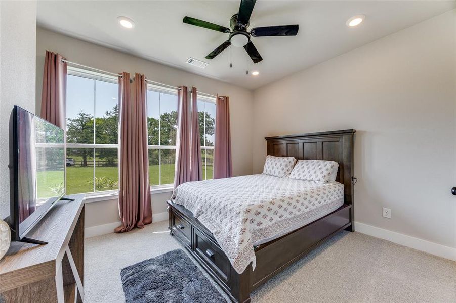 Bedroom featuring light carpet, ceiling fan, and recessed lighting