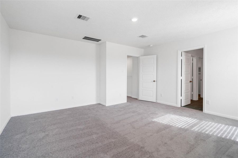 Additional view of the primary bedroom looking towards the primary bathroom.
