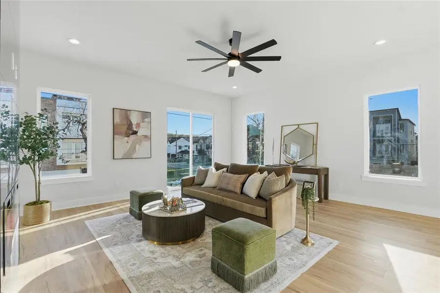 Living room with light wood-style floors, ceiling fan, and recessed lighting Living room with light wood-style floors, ceiling fan, and recessed lighting