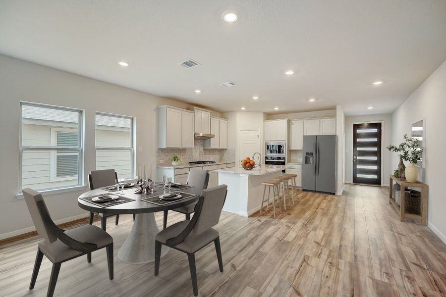 Virtually staged dining room and kitchen in the Pearl floorplan at a Meritage Homes community.