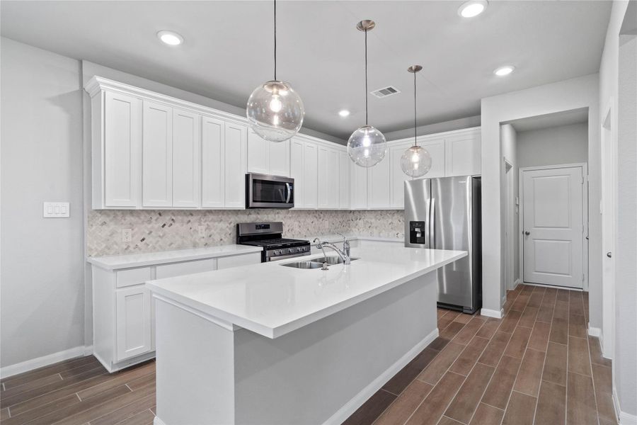 The expansive quartz-topped island stands as the home's true heartbeat, offering a natural gathering spot where family and friends naturally gravitate to share meals, conversation, and connection.