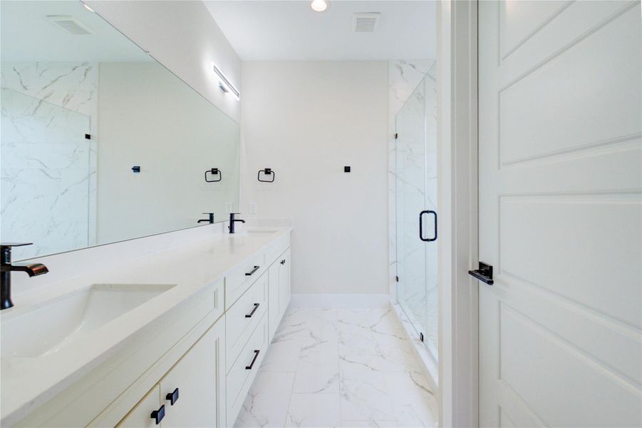 Spa- like inspired primary bath feature black fixtures and hardware. Spa- like inspired primary bath feature black fixtures and hardware.