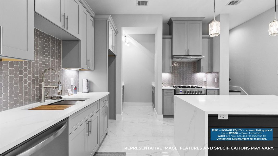 Cooking feels effortless with the sleek navy cabinetry, gold fixtures, and plenty of counter space to spread out and create.