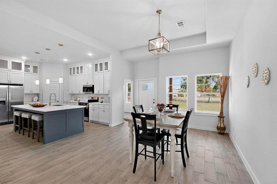 Dining space with light wood finished floors and recessed lighting Dining space with light wood finished floors and recessed lighting