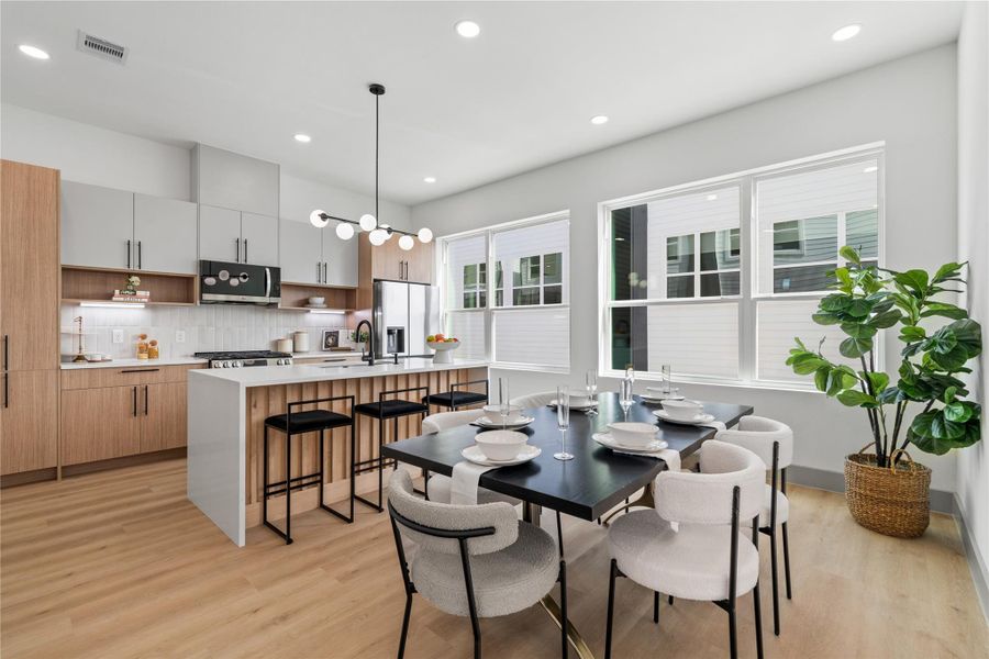 Thoughtfully designed with clean lines and elevated finishes, this kitchen-dining combo features custom flat-panel cabinetry, soft-close drawers, quartz countertops, and a spacious island with waterfall detail—bathed in natural light from oversized energy-efficient windows. Thoughtfully designed with clean lines and elevated finishes, this kitchen-dining combo features custom flat-panel cabinetry, soft-close drawers, quartz countertops, and a spacious island with waterfall detail—bathed in natural light from oversized energy-efficient windows.