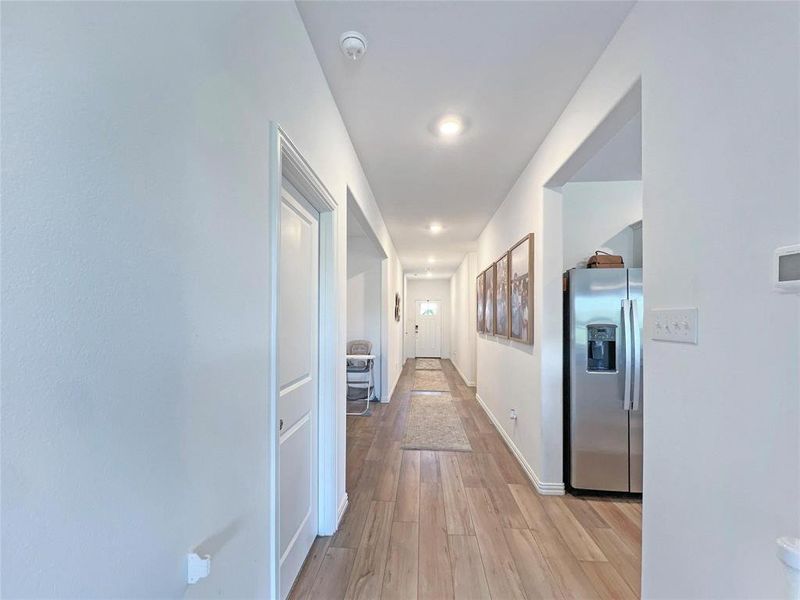 Hall with light wood-style flooring and baseboards