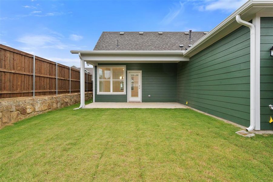 Rear view of property featuring a patio area and a yard