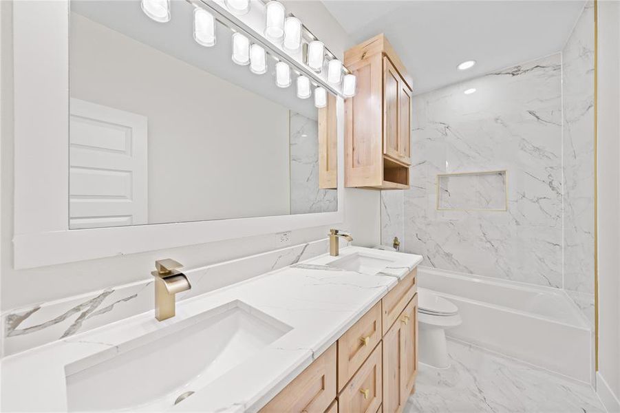 Bathroom featuring double vanity, light marble finish floors, bathing tub / shower combination, and recessed lighting Bathroom featuring double vanity, light marble finish floors, bathing tub / shower combination, and recessed lighting