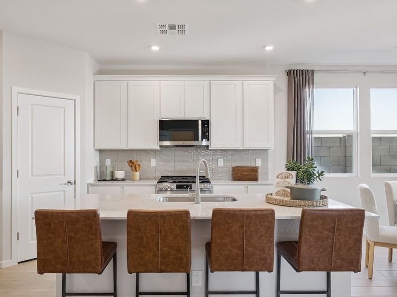 A kitchen with white cabinets.