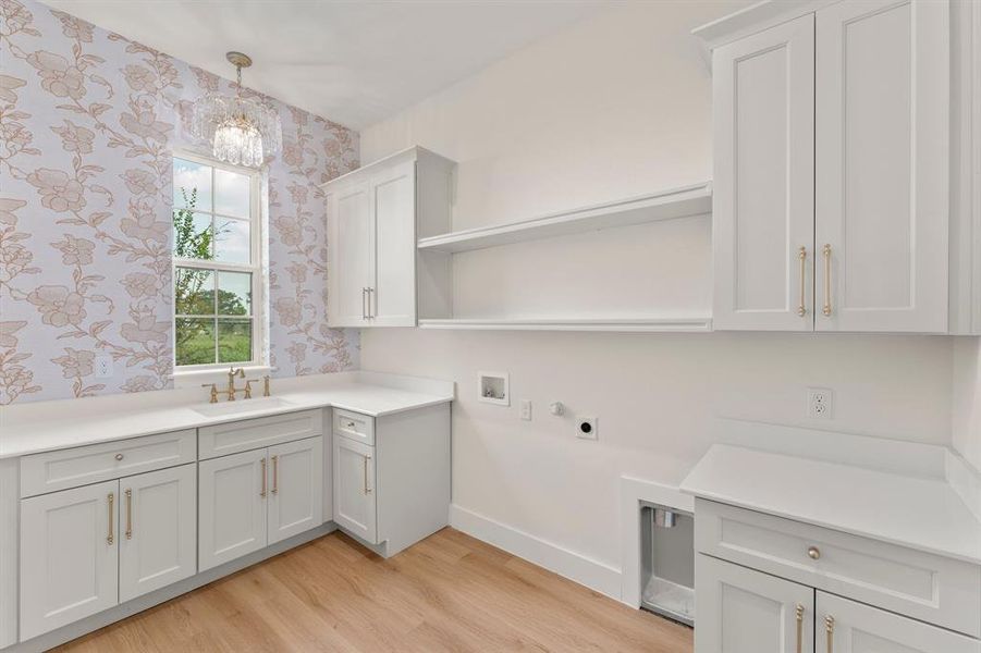 Laundry area with washer hookup, light wood-type flooring, cabinet space, hookup for a gas dryer, and hookup for an electric dryer