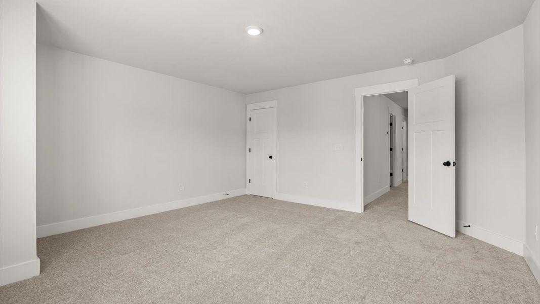 Notable secondary bedroom offering cozy carpeted flooring and a stylish walk-in closet