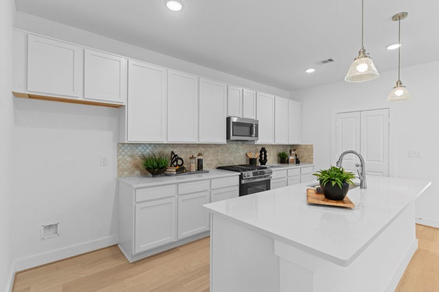 A closer look at the kitchen shows off its stylish design and modern finishes. With plenty of counter space and storage, it’s the perfect spot for everyday meals or hosting guests. French doors open to the large pantry.