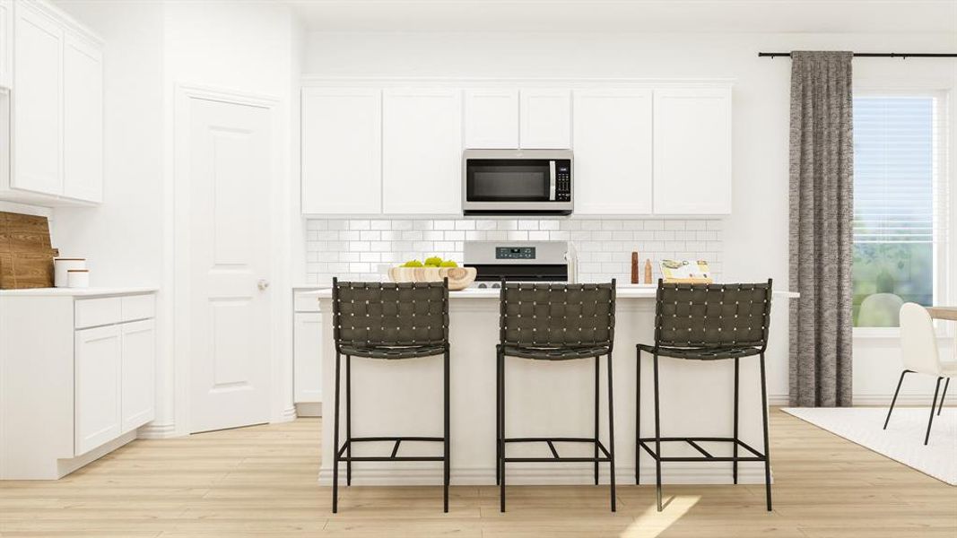 Kitchen featuring a breakfast bar, tasteful backsplash, light wood-type flooring, appliances with stainless steel finishes, and white cabinets