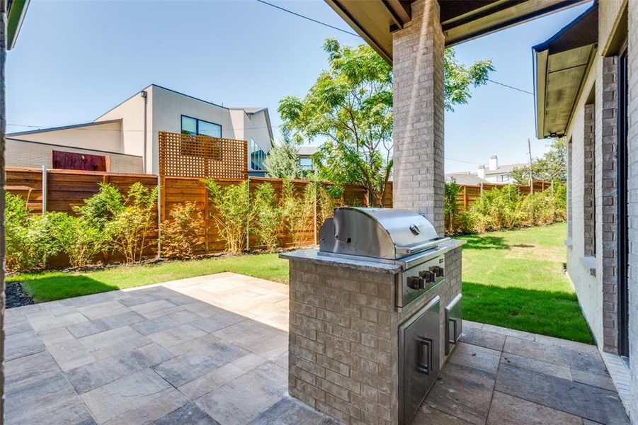 Fenced backyard with a patio and an outdoor kitchen Fenced backyard with a patio and an outdoor kitchen