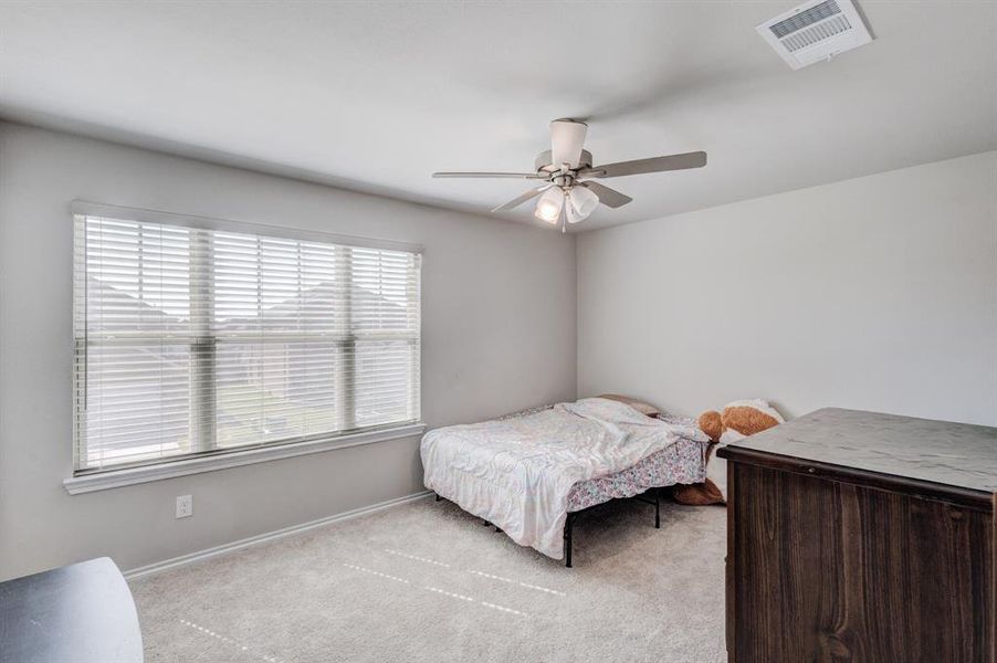 Carpeted bedroom featuring baseboards and ceiling fan Carpeted bedroom featuring baseboards and ceiling fan