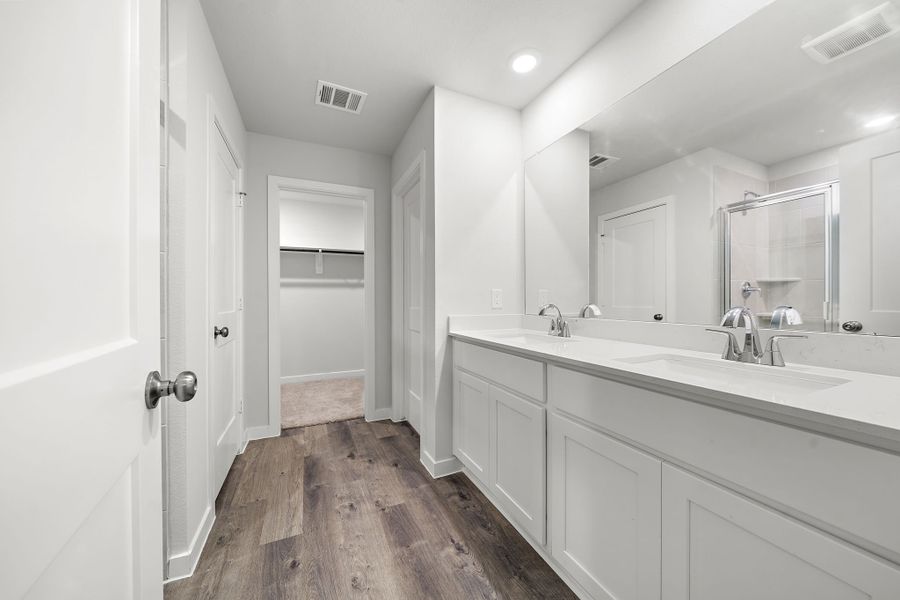 A bathroom with white cabinets.