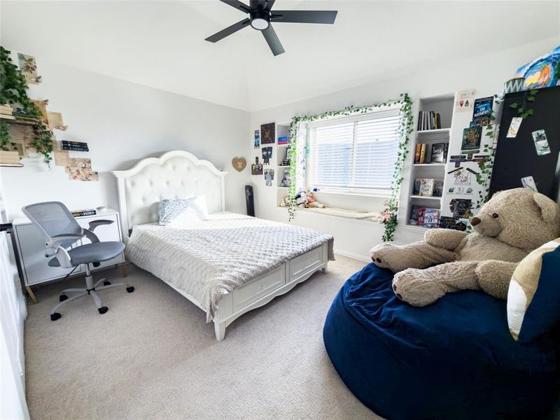 Bedroom featuring carpet, ceiling fan, vaulted ceiling, and a desk