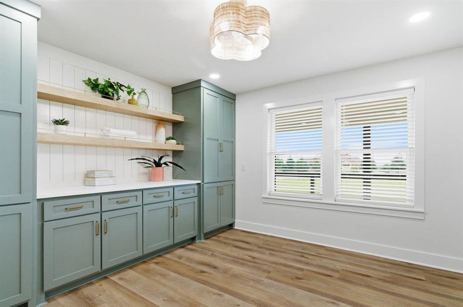 This room features wood-look flooring, two windows with blinds, and recessed lighting This room features wood-look flooring, two windows with blinds, and recessed lighting