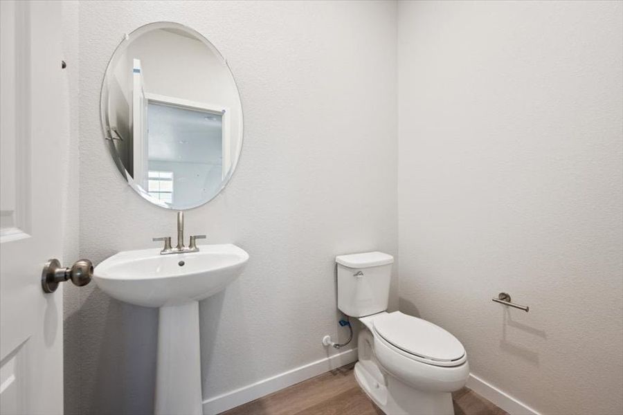 A bathroom with a round mirror.
