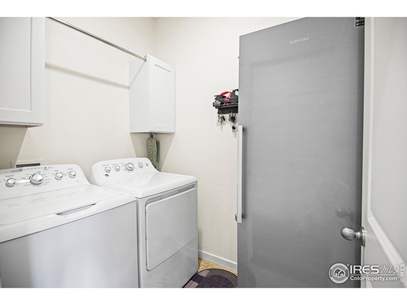 main level laundry with cabinets and hanging rack