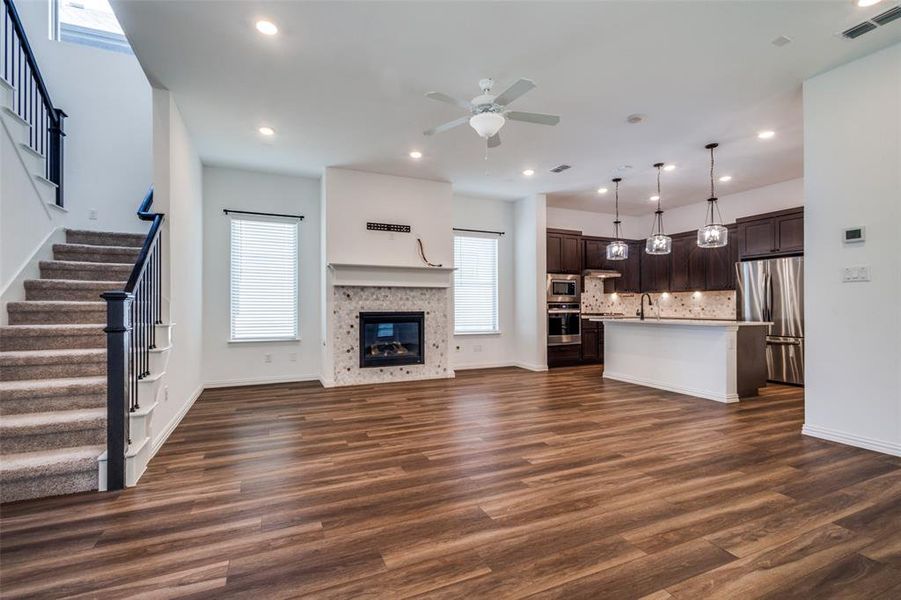 Unfurnished living room with dark hardwood / wood-style flooring, ceiling fan, and sink