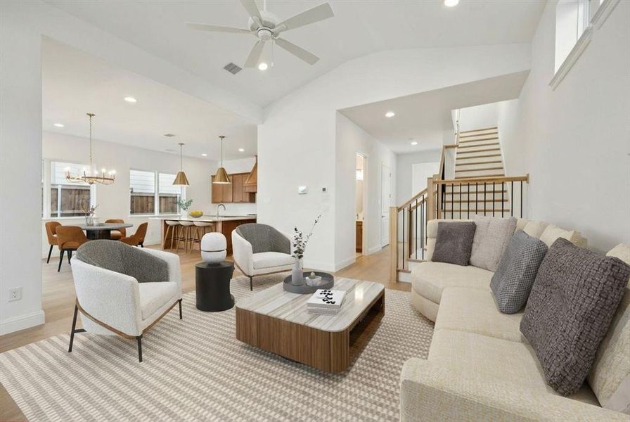 Living area featuring vaulted ceiling, light wood-type flooring, a ceiling fan, and hanging lights Living area featuring vaulted ceiling, light wood-type flooring, a ceiling fan, and hanging lights