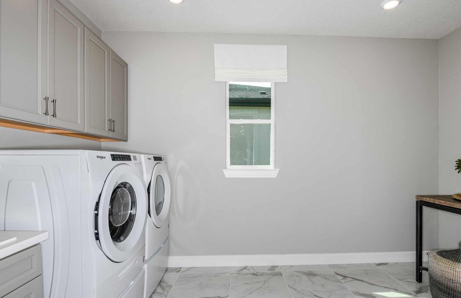 Oversized Laundry Room with Built-In Cabinets and Sink