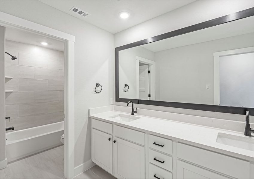 The secondary bathroom has a sprawling dual sink vanity and a shower-tub combo. The secondary bathroom has a sprawling dual sink vanity and a shower-tub combo.