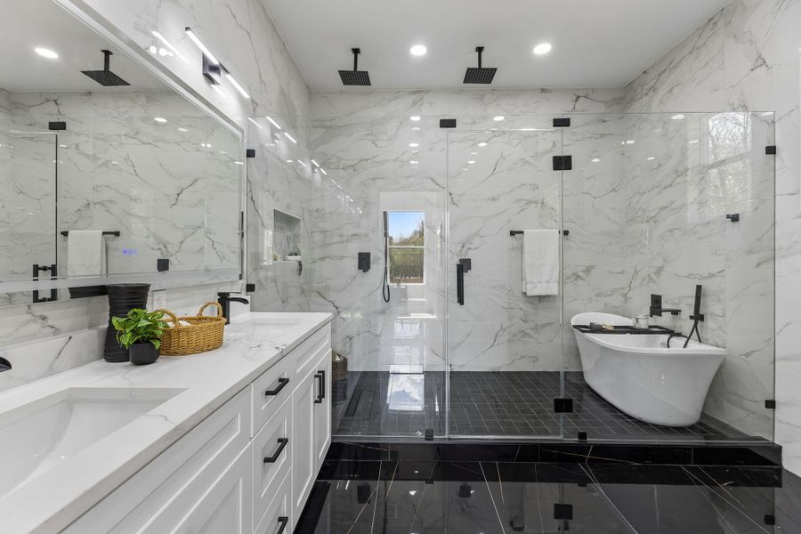 Elegance defines this space with stone counters, a soaking tub, and custom marble tiling.