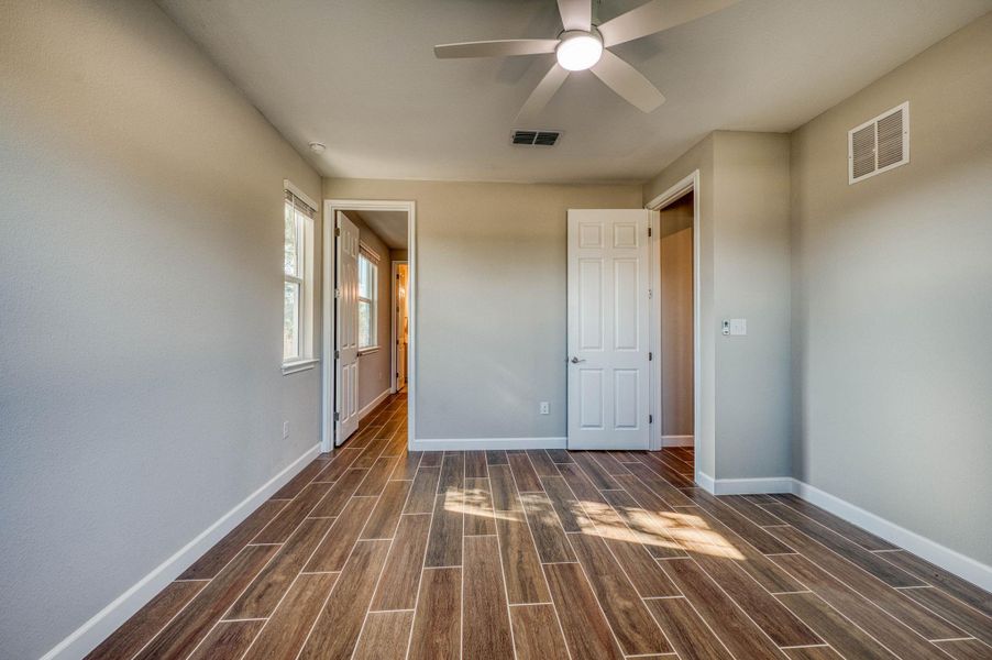 Gleaming wood-look tile floors and crisp white trim enhance this versatile bedroom space. Gleaming wood-look tile floors and crisp white trim enhance this versatile bedroom space.