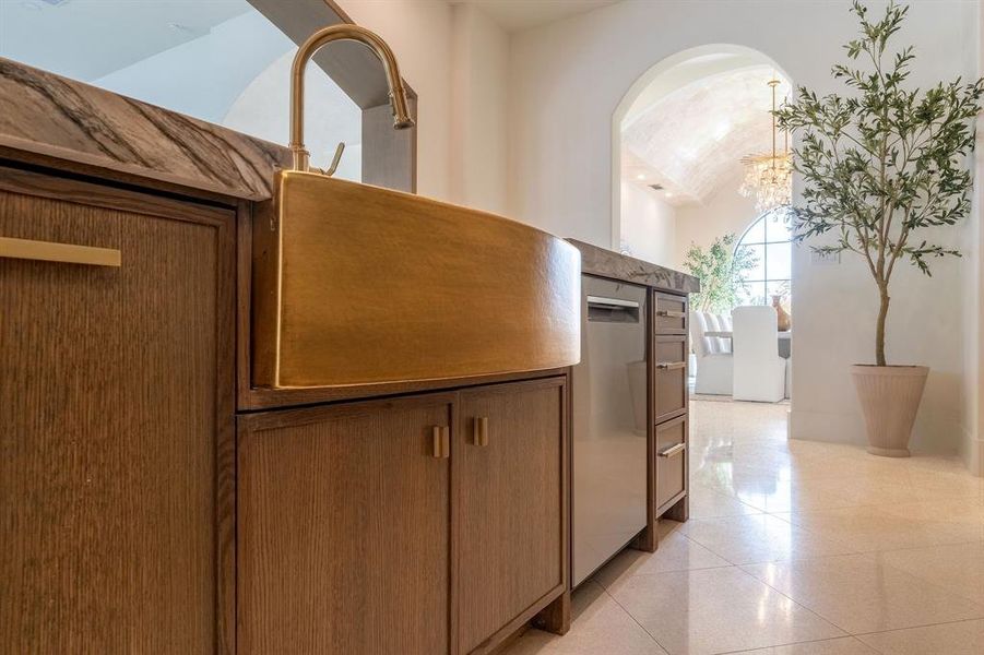 Hallway featuring light tile patterned floors, a chandelier, and vaulted ceiling