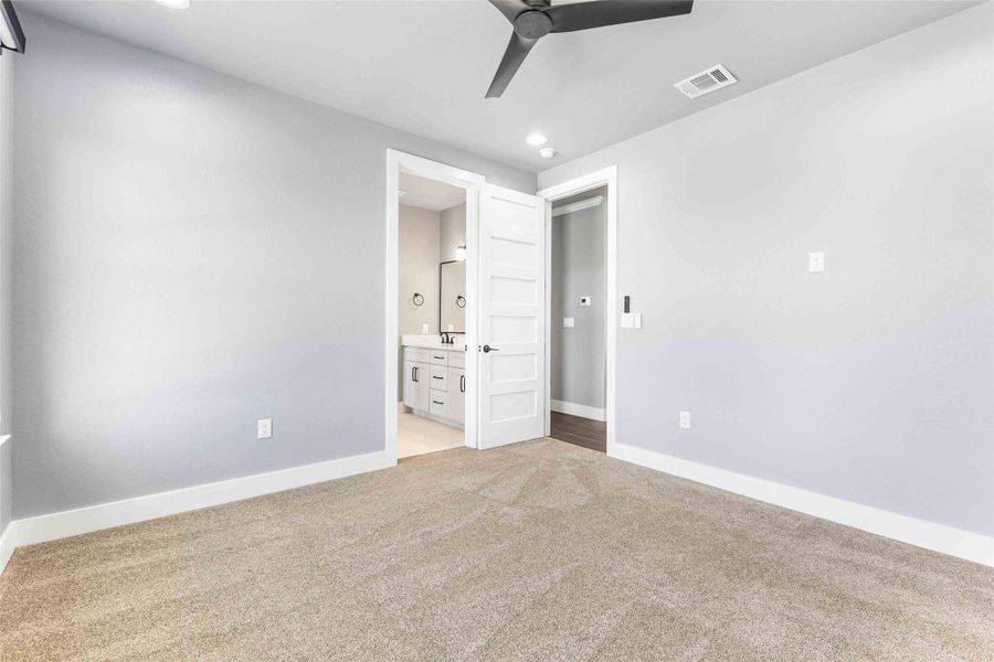 Unfurnished bedroom featuring ensuite bath, light carpet, a ceiling fan, and recessed lighting Unfurnished bedroom featuring ensuite bath, light carpet, a ceiling fan, and recessed lighting